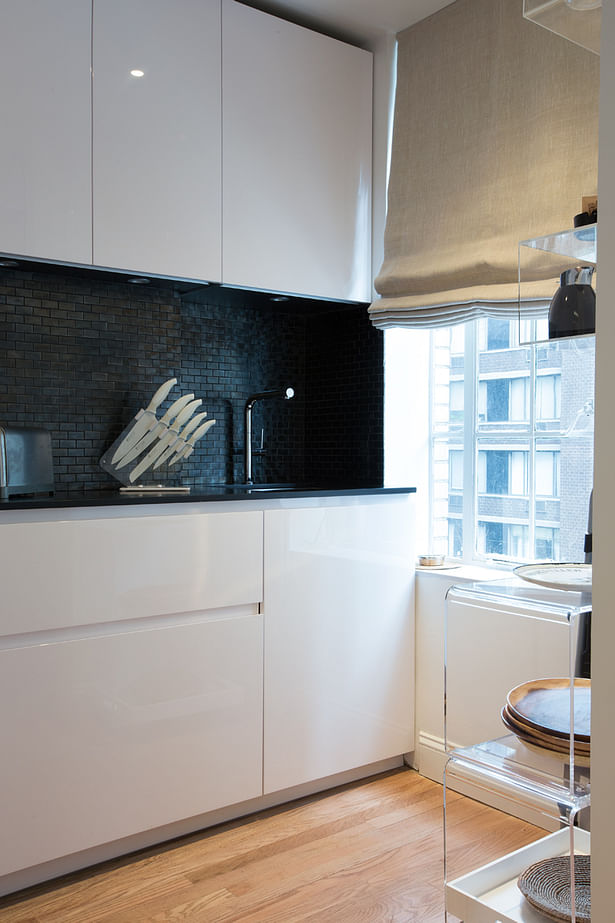 The black glass mosaic backsplash completes the elegance of the design creating silver reflections. 