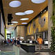 The David Rubenstein Atrium at Lincoln Center in New York City, which cobbles together 7,000 square feet of new public space for performances and Lincoln Center visitors out of the interstitial spaces between buildings. Newcomers and Lincoln Center regulars are treated to a 20-foot tall green wall and 16 skylight oculi, playfully scattered across the ceiling. (Image via twbta.com)