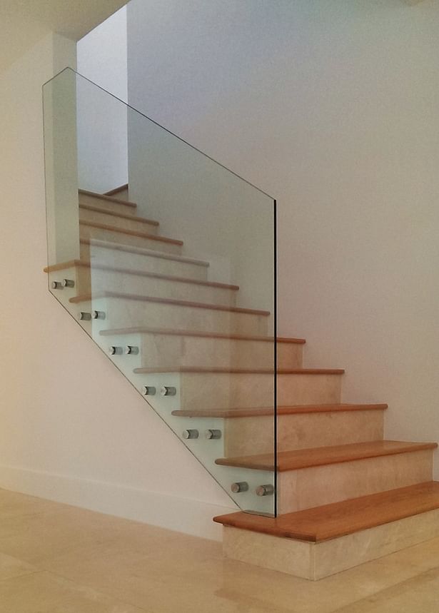 Stainless steel standoffs were side mounted to anchor the new glass railing.