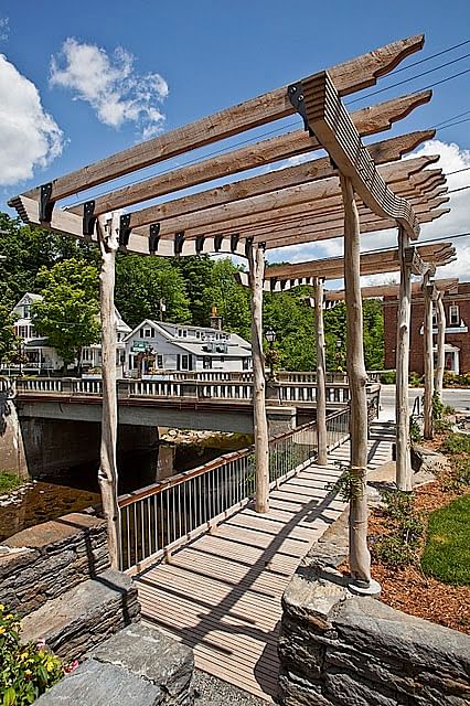 The Bank Park arbor and deck rest on the foundation of the Old Bank Building that burned down in 2003. The arbor structure gave new life to dead tree limbs found on the site. The new plants were grown at a local nursery and selected by resident Master Gardeners.