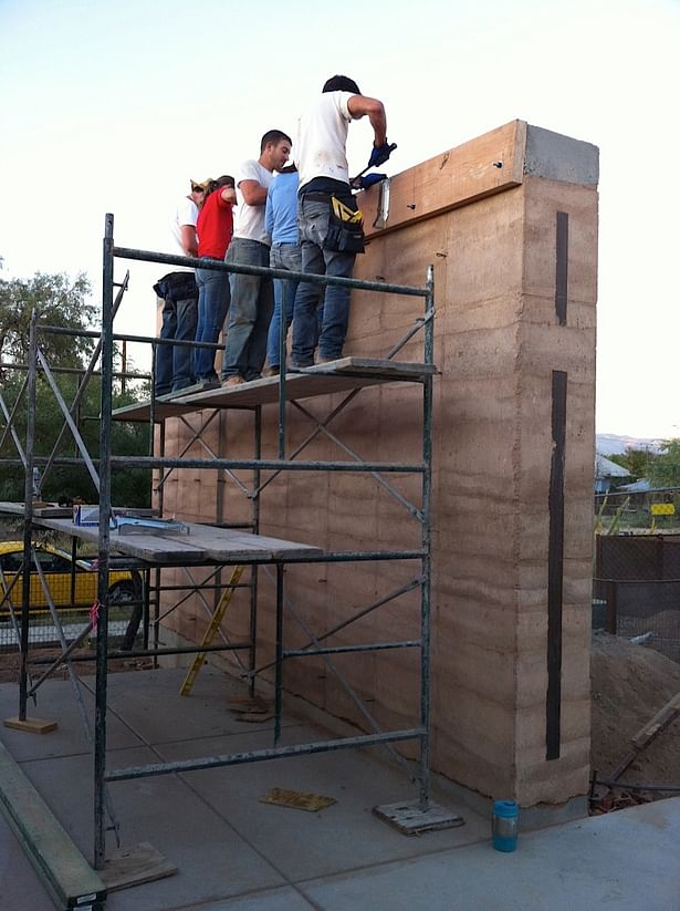 attaching ledgers for roof construction on completed rammed earth wall