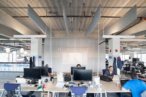 Open office area and teamwork zone with custom acoustic baffles fabricated by Synecdoche.