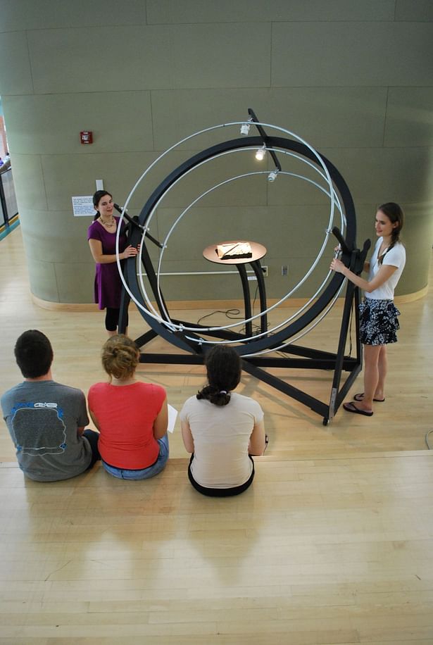 Kara Knechtel (left) and Dominique Doberneck (right) demonstrating the use of the heliodon to third year students, using a site model from their current studio project.