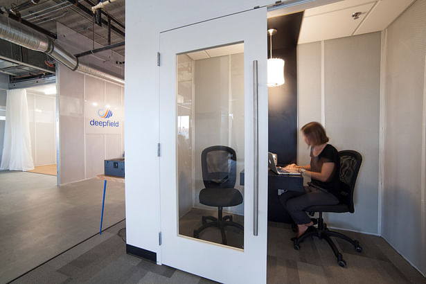 Phone room with perforated metal mesh walls embedded with acoustic cellulose panels.