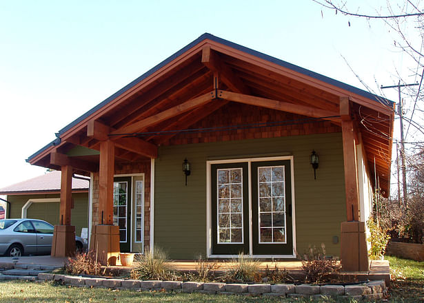 The custom heavy timber and steel tension rod truss system rests on stained concrete column base.