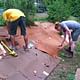 Digging through the cardboard. It rained that morning which helped make the cardboard easier to cut through. 