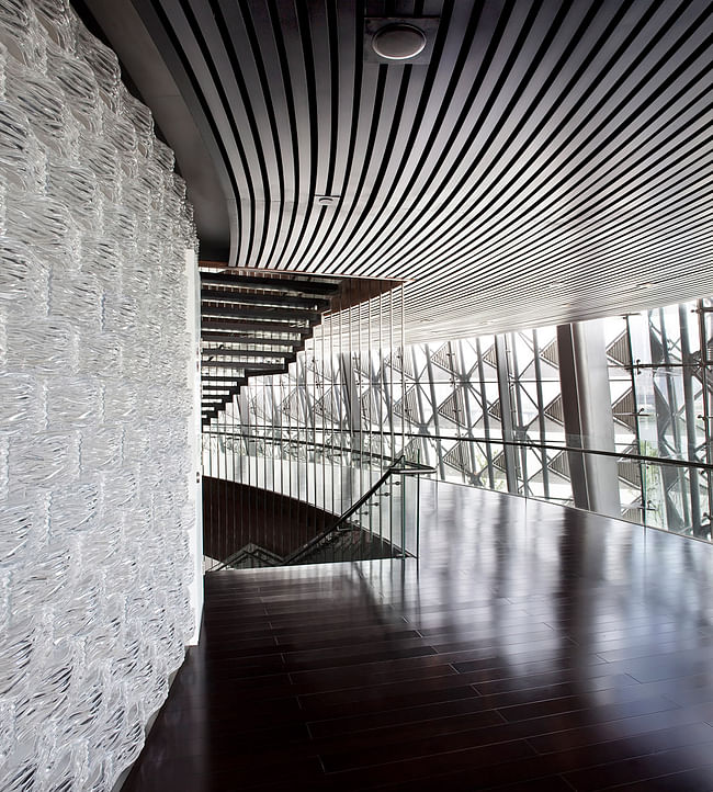 The glass brick wall in the main auditorium lake side lobby is made of 20.000 glass bricks with a wave pattern relating to the surrounding lake and to the curved bamboo block wall inside the auditorium. (Photo: Kari Palsila)