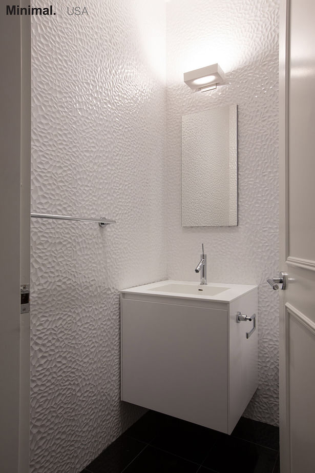 The cube vanity integrates in this bathroom a square sink, carved directly from the top made of Corian.