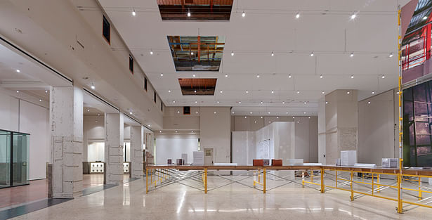 What was once the postal sorting room is now the main gallery space. The overhead catwalk and windows remain in place where postal security once watched the postal sorting process. Cable lighting spans the space and the lights float in the volume. A new ceiling plane was suspended below the existing plaster ceiling.