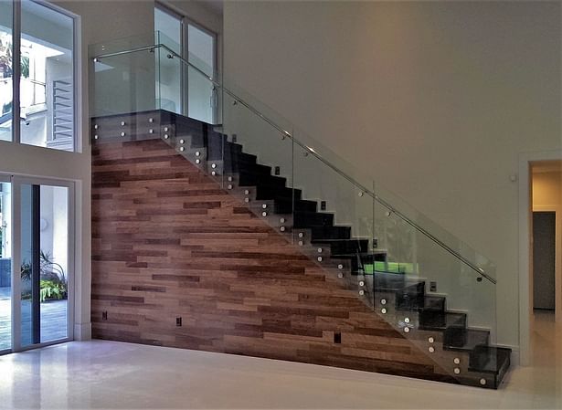 Featuring clear glass railings with a stainless steel handrail.