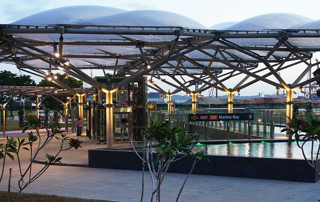 The canopy and reflective pool help integrate the Marina Bay Station into the park environment.