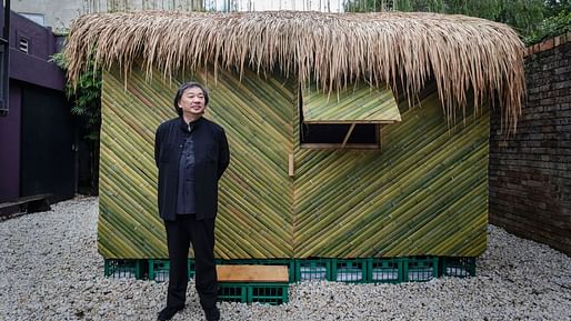 Shigeru Ban posing with a replica of one of his shelters made from green bamboo to address the earthquake in Ecuador. Photo: Brook Mitchell​