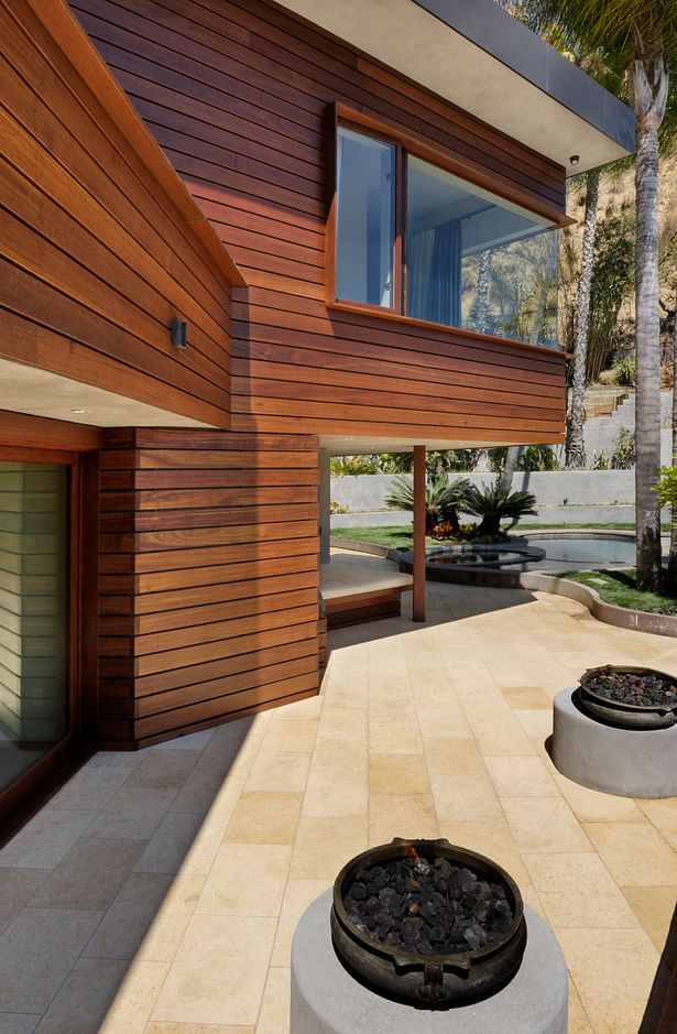 The intimate outdoor living room sits to the West-side of the home and includes a built-in sofa, twin fire pits and white travertine pavers. It leads to the outdoor dining room, the home’s primary dining area.