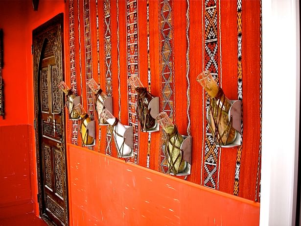 Restaurant vestibule with traditional 'cliches' such as Berber wall hanging, lanterns [not shown], heavily carved door and spice containers [which are actually modified army surplus urine bed pans]