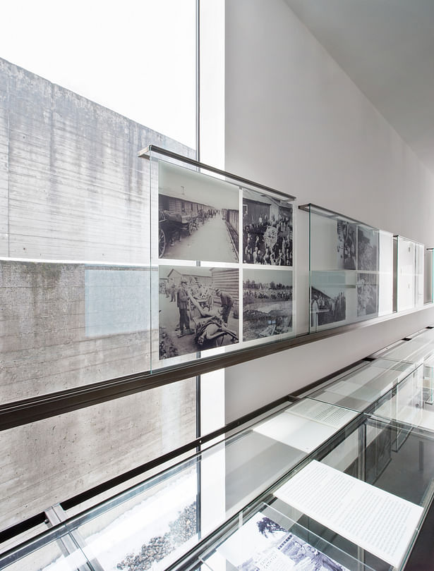 The view of the surrounding wall of the memorial is overlaid with exhibition objects showing the killing and extermination of inmates.