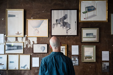 Patron studying 'Interiors of Memories' at the opening night of MIARD graduation exhibition. Photo by Aad Hoogendoorn.