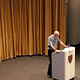 [Gold lamé curtain, with Mark Jarzombek in the foreground.] in Piper Auditorium by Lian