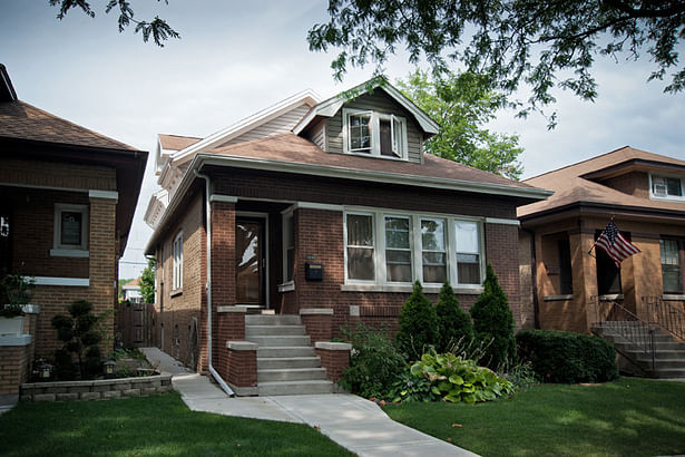 The front facade, with the new addition just barely peeking out above the existing front elevation