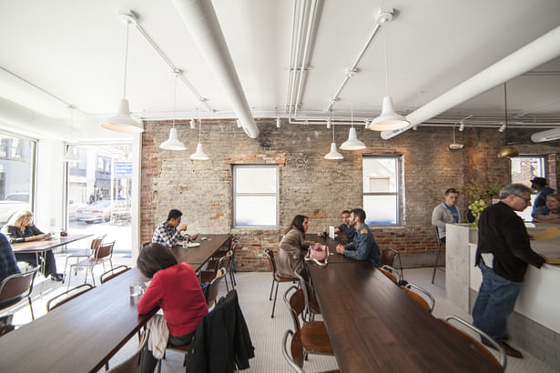 Spencer dining area with walnut tables. Synecdoche Design