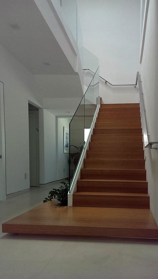 Clear glass railings with a stainless steel flat-bar handrail.