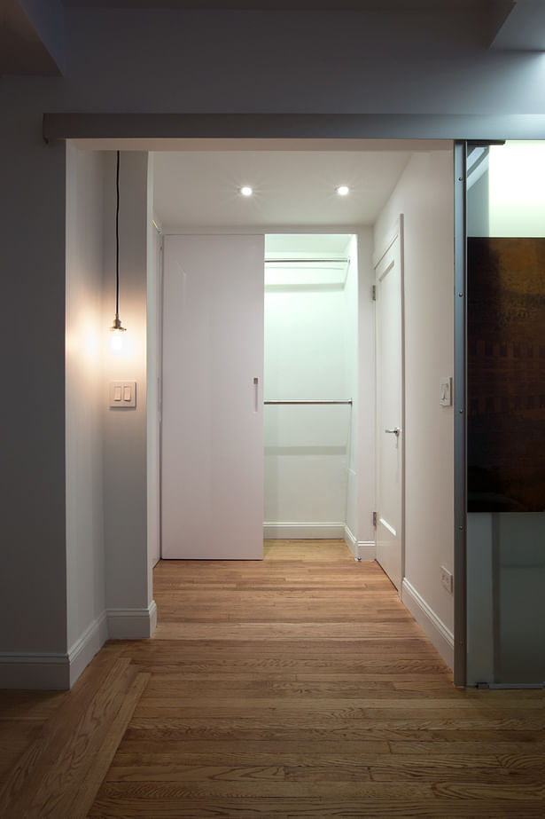 These doors in glossy white lacquer, not only are a sleek solution, but are also functional, since they can slide sideway, creating light plays that give depth to the small area that takes to the bathroom.