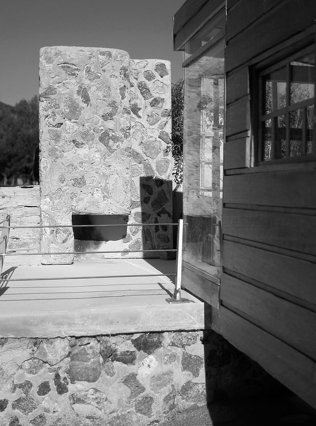 The fully-functional exterior fireplace is the highlight of the home design project. It acts as a mood-setting feature, and it is flanked by an intimate, landscaped area partially enclosed against the elements by concrete retaining walls. The views south of the patio are preserved while the rear of the patio features a picture window cut in the concrete. This features a view up the mountain to the north of the property.