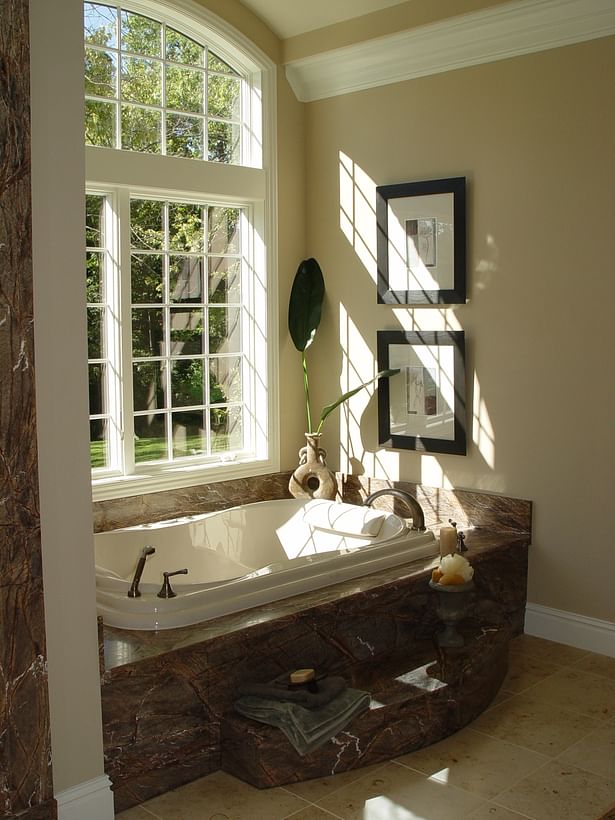 Stone tub surround and arched window details make for an inviting master bath.