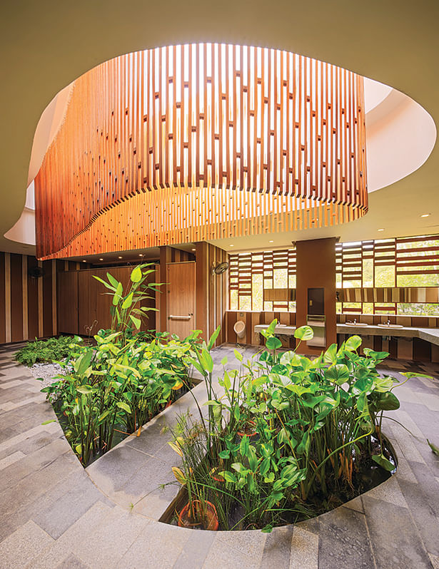 The central skylight with a wooden trellis veil enlivens the interior of the bathrooms in the entrance plaza zone, while preventing rainwater from splashing into the space