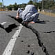 A man sticks his head in a rift opened up in the street by the Napa earthquake. Credit: Lisa James / Register