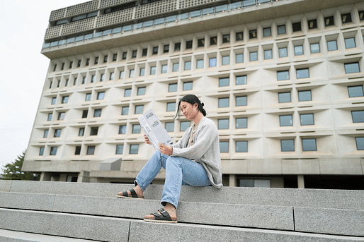 A UMass Amherst student reading the Brutalist Campus Guide. Photo: John Solem 