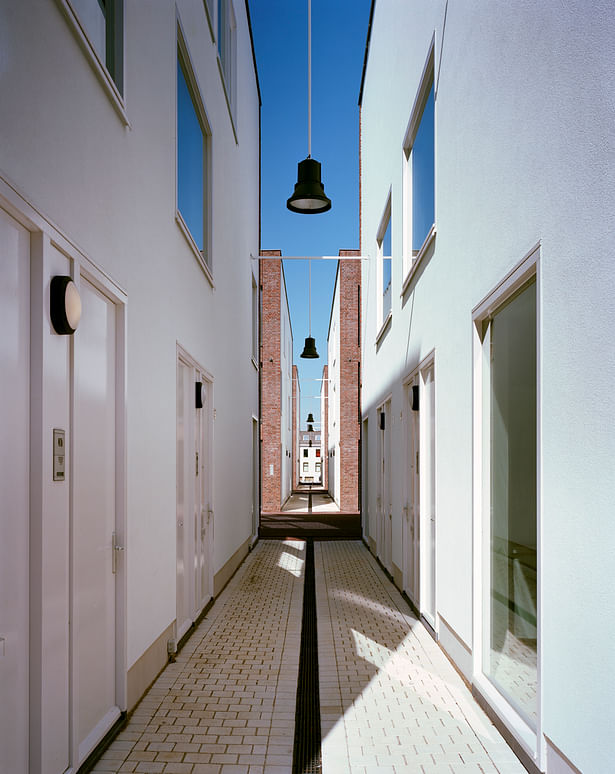 bright white alley facades with large windows and main entrances to the houses, ensure liveliness and interaction 