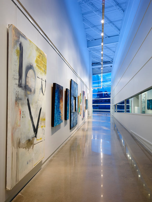 The art gallery and boat storage spaces are placed side by side to illustrate their connection. Track lighting and blue atmospheric lighting create universal space. 