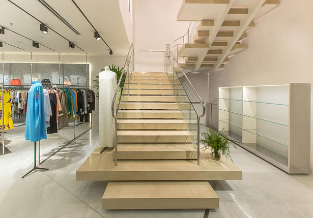The climax is represented by the monumental staircase of beige Hauteville stone from Southern France: huge stone slab as steps expand the sales floor area, accompanying clients onto the second floor of the store on a journey through a unique luxury shopping experience. 