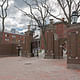 The U-shaped entry consists of a central carriage gate flanked by urn-topped brick piers and arched foot gates. The thin spire of Harvard’s Memorial Church rises in the background. Image credit: Ralph Lieberman