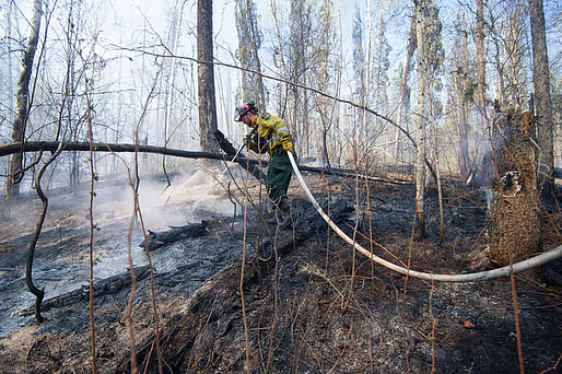 A member of Wildfire Management Alberta's Wild Mountain Unit out of Hinton, hoses down hotspots in the Parsons Creek area of Fort McMurray Friday, May 5, 2016. Photo by Chris Schwarz/Government of Alberta.
