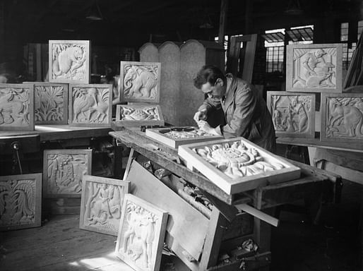 Denis Dunlop working in his studio on the panels of a screen representing the fauna, industries, people and flora of the five Dominions, to be installed in the Henry Florence Memorial Hall of the Royal Institute of British Architects, 66 Portland Place, London – from RIBApix 