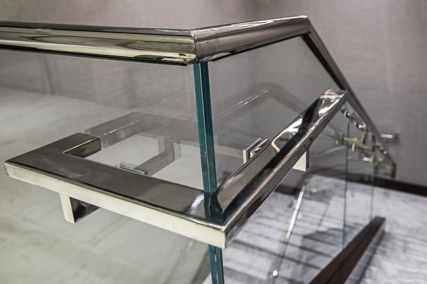 Rounded stainless steel cap rail & flat bar handrail mounted to glass panels 