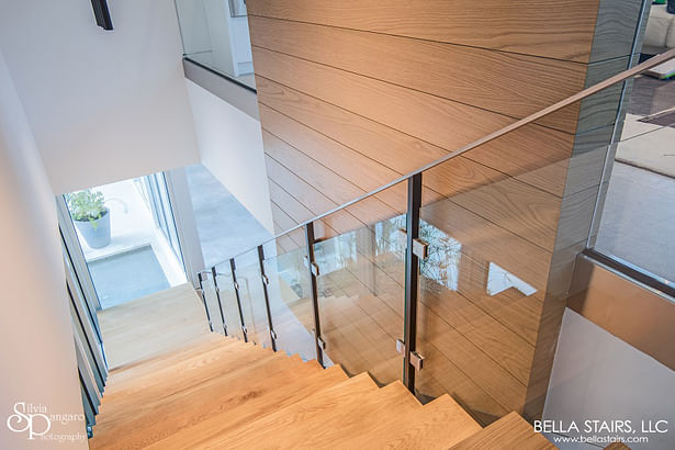 White Oak Wood Treads, Laminated Glass Inlay Railings, Custom Painted Steel Posts, & a Top-mounted Stainless Steel Handrail.