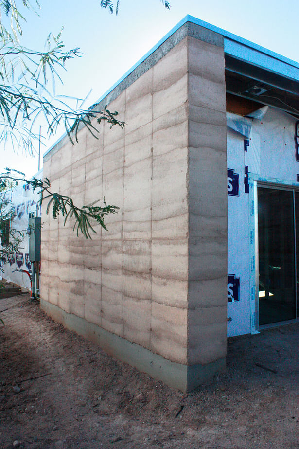completed rammed earth wall + wood framed walls