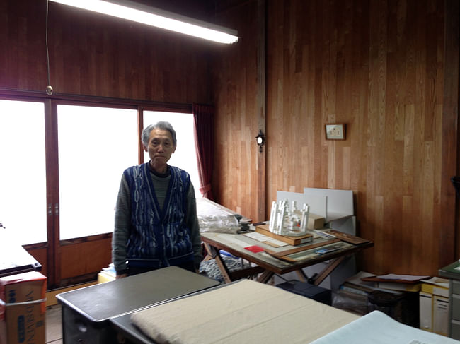 Yanai San standing in his home office