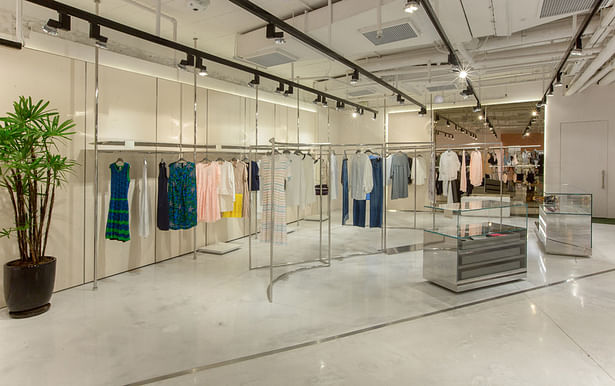 Inside, large glass displays composed of mirrored surfaces of polished steel and lacquers in pastel shades enhance the fashion collections, making the garments visible and appealing