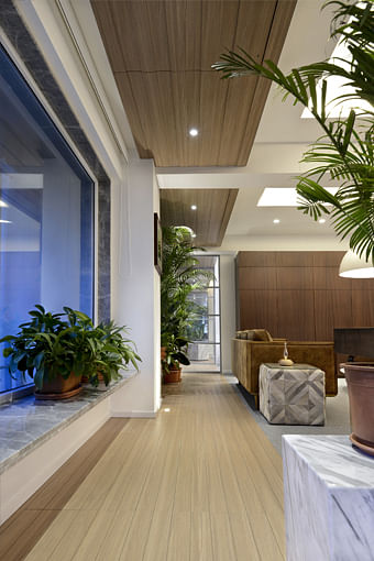 A green internal balcony is designed as a filter for too bright daylight as well as to hide the other less attractive office buildings from view.