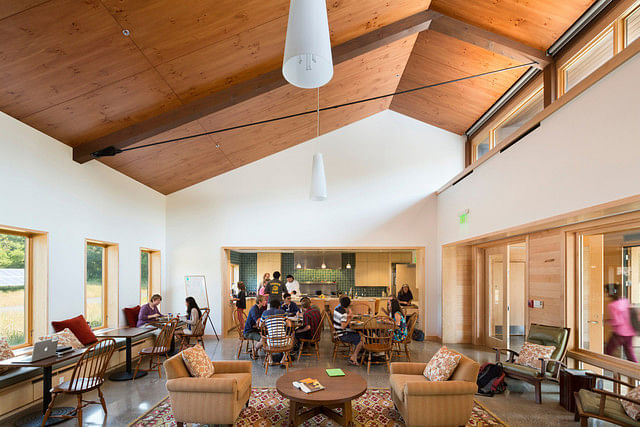 The common room of the Kohler Environmental Center. High windows offer ample daylight and summer cross ventilation. Students learn cooking techniques at an open kitchen beyond. Photographer: Peter Aaron/Robert A. M. Stern Architects via Bloomberg 