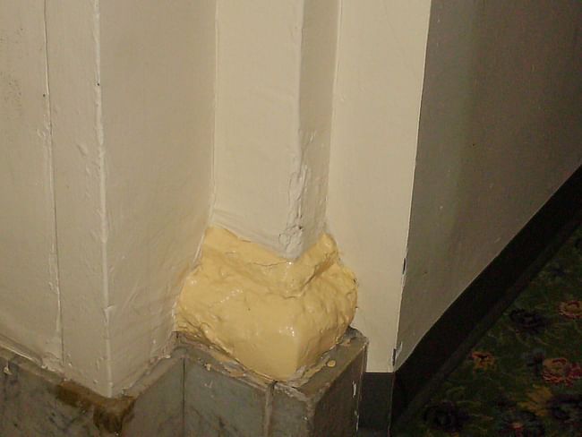 What used to be a beautiful detail, baseboard of granite and a gilt-finish plaster-work pilaster decoration. Today it looks like someone literally threw a bucket of paint onto it and didn't bother to clean it up!!!