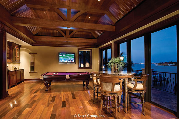 The game room has stunning exposed ceiling rafters and a retreating glass wall to the back patio.