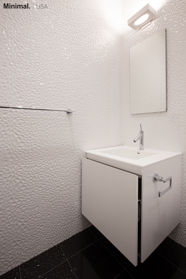 The cube vanity integrates in this bathroom a square sink, carved directly from the top made of Corian. Minimal USA has provided the fixtures also for the tub/shower.