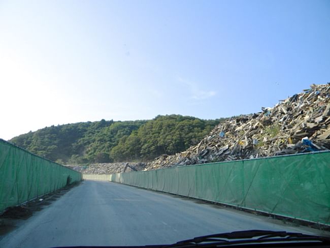 Piles of Debris on our way to Onagawa Temporary Housing about atleast 2 kilometers at an average of 25' high.... Literally a sh*t ton of trash with nowhere to go..for now I hope. via John Tubles